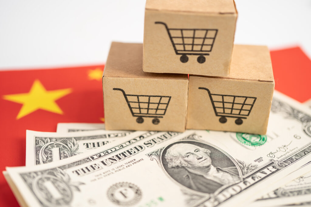 Shopping cart logo on box with US dollar banknotes on China flag